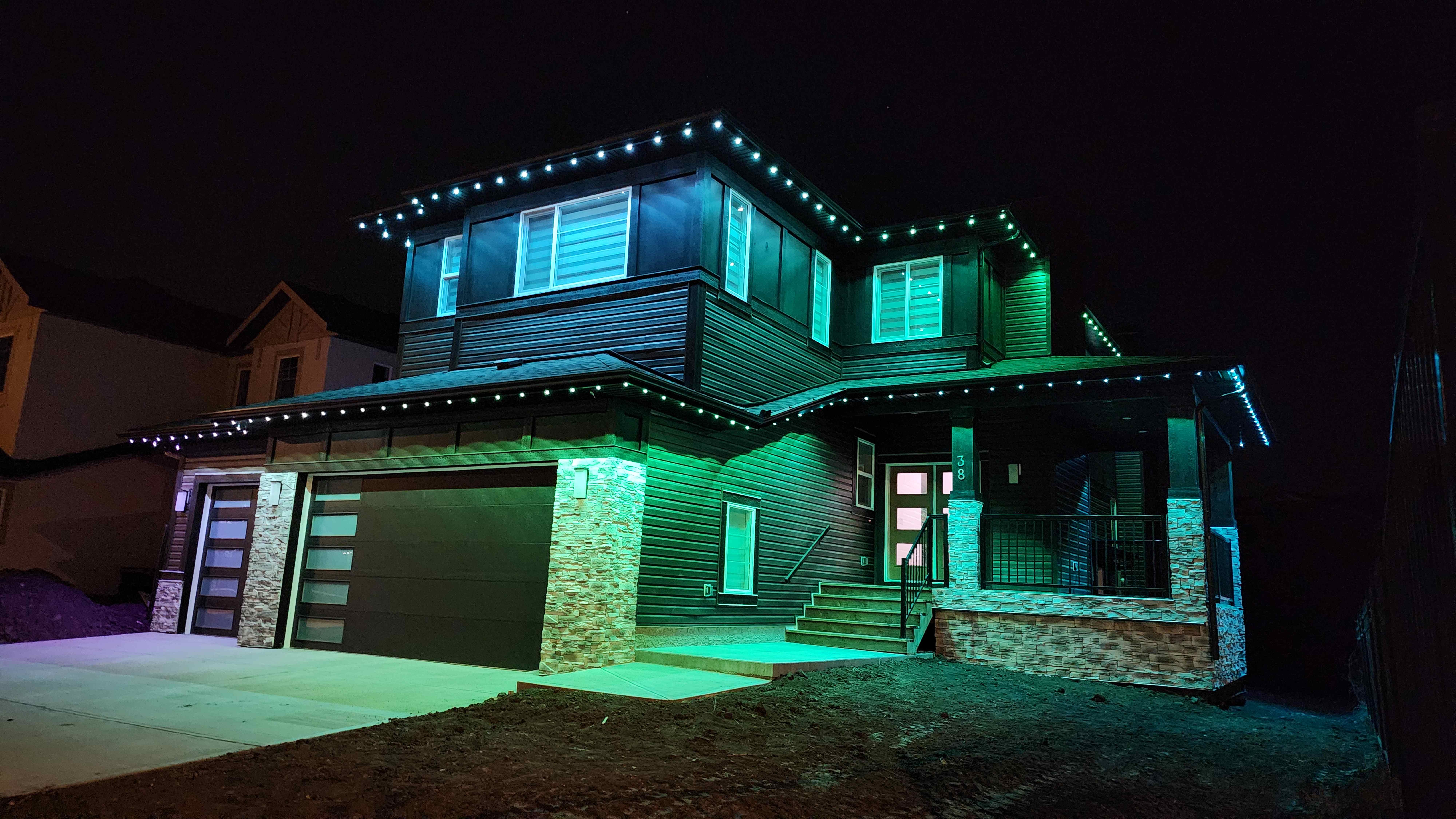 A modern two-storey Govee Calgary install outlined in crisp green and teal permanent lighting