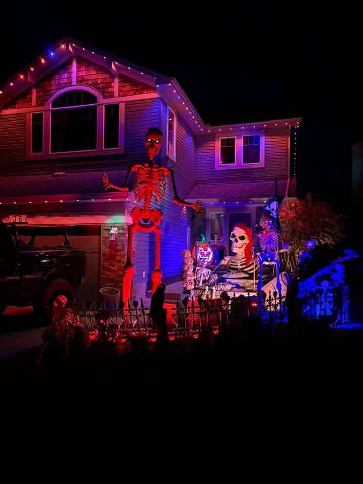 Calgary home decorated for Halloween with a giant skeleton, lit in orange and purple with the Govee Permanent Outdoor Lights Pro