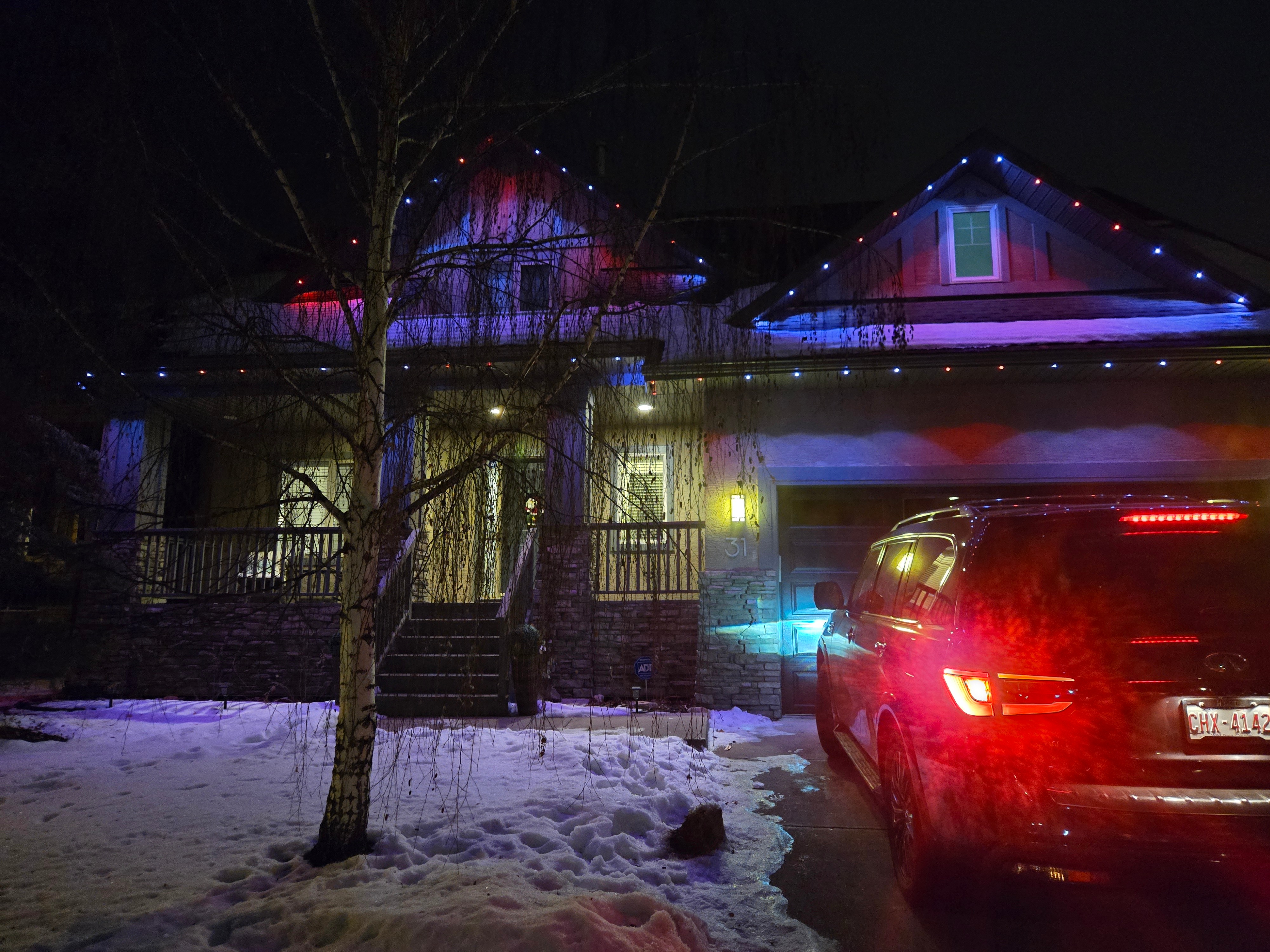Craftsman home lit in a red, white and blue pattern along every roofline