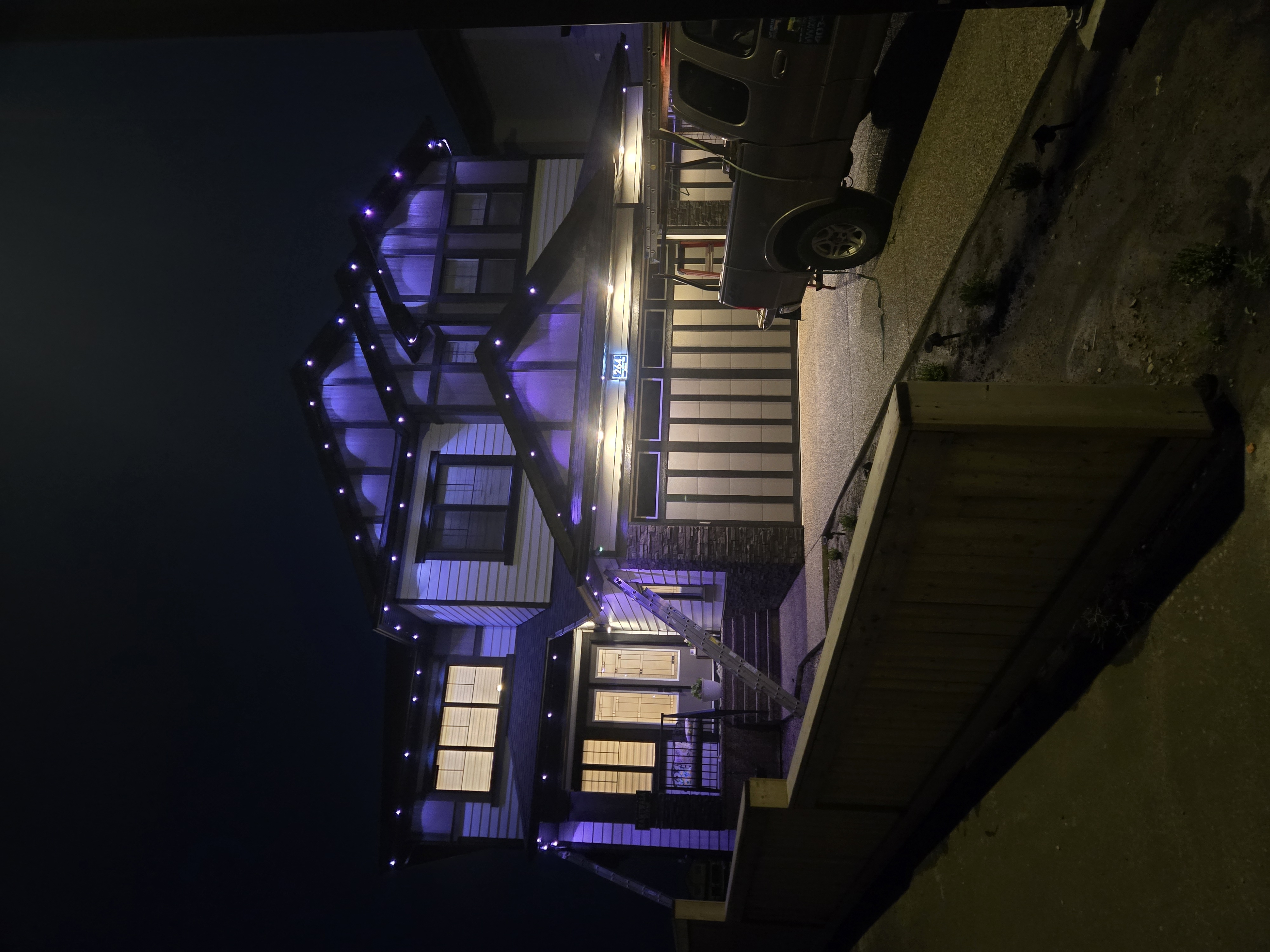 Craftsman home with every roofline outlined in blue and purple permanent lighting