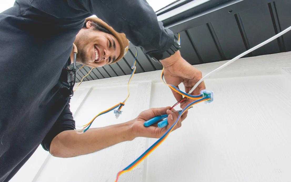 A Trimlight technician installing permanent holiday lights